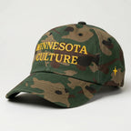 Camo colored dad hat, that that says "MINNESOTA CULTURE" in gold embroidery on the front panel, with gold embroidered 4 point north star on left panel