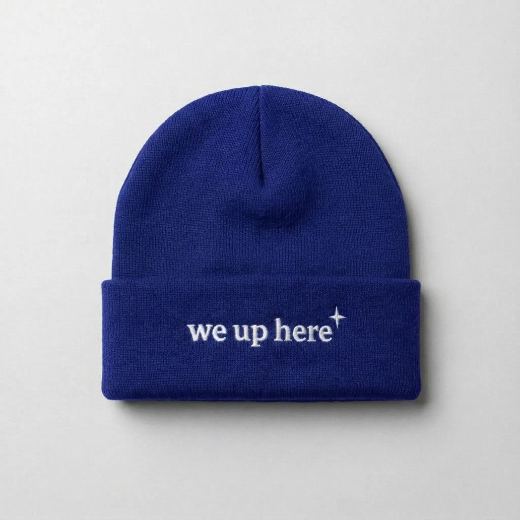 Royal Blue cuffed beanie with "we up here" embroidered in white text, and a small white north star accent